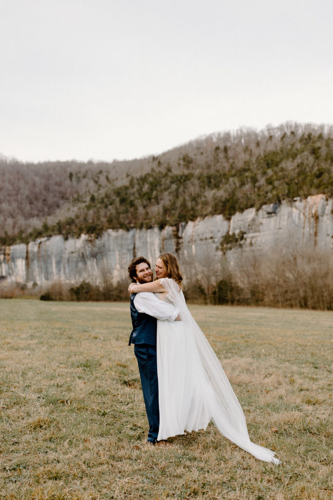 bride and groom holding each other with painted bluffs in the background-- Arkansas elopement locations