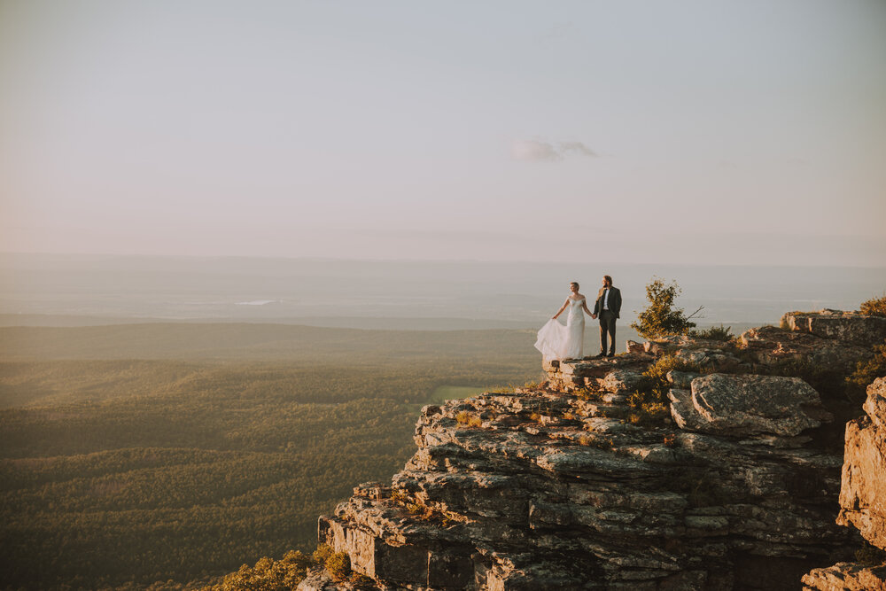 couple holding hands on cliff looking out at view -- Arkansas elopements 