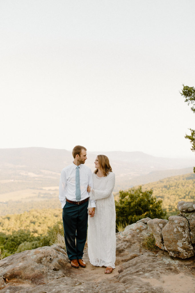couple smiling and holding each other with scenic backdrop -- sams throne elopement