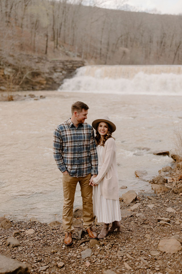 couple smiling at camera and holding hands -- northwest arkansas engagement photos 