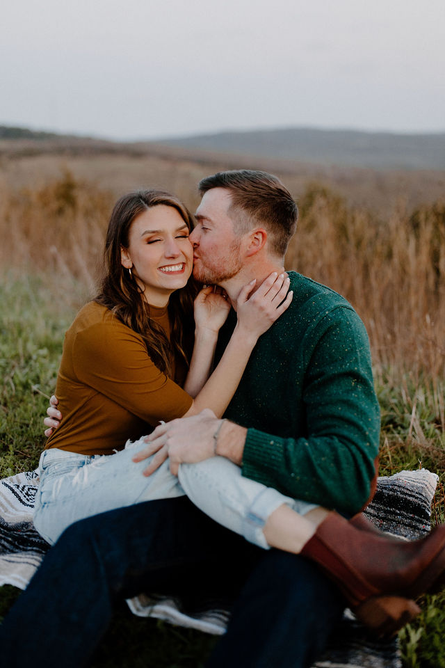 man kissing woman on cheek as they sit together -- arkansas elopement photographer